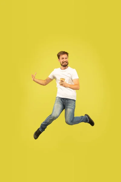 Full längd porträtt av Happy Jumping man på gul bakgrund — Stockfoto
