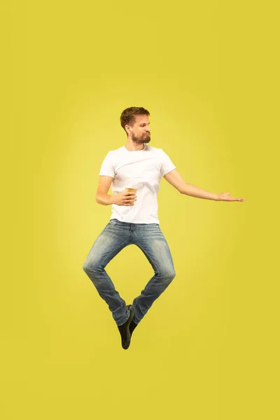 Pełna długość portret szczęśliwy skoki człowiek na żółtym tle — Zdjęcie stockowe