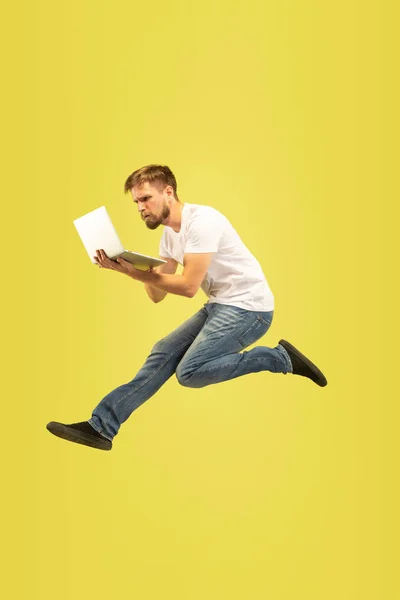 Sarı arka plan üzerinde mutlu atlama adam tam uzunlukta portre — Stok fotoğraf