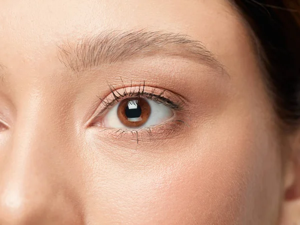 Close up shot of well-kept female big eyes and cheeks on white studio background — Stock Photo, Image