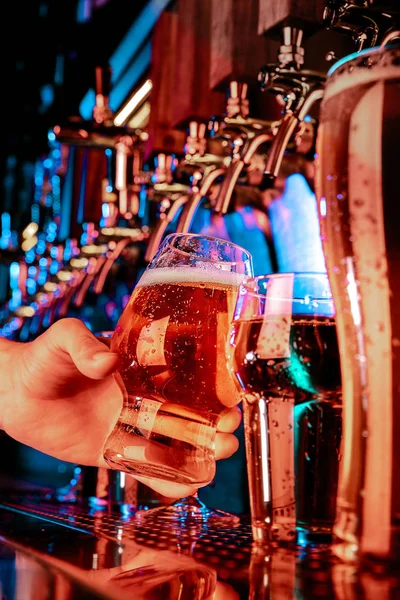 Mano de cantinero vertiendo una gran cerveza lager en el grifo — Foto de Stock