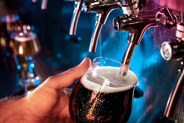 Hand of bartender pouring a large ale, porter, stout beer in tap — Stock Photo, Image