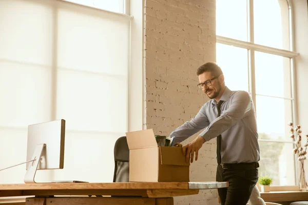 Un giovane uomo d'affari che si trasferisce in ufficio, ottenendo un nuovo posto di lavoro — Foto Stock