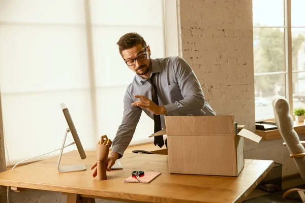 Un joven empresario que se muda a la oficina, consiguiendo un nuevo lugar de trabajo — Foto de Stock