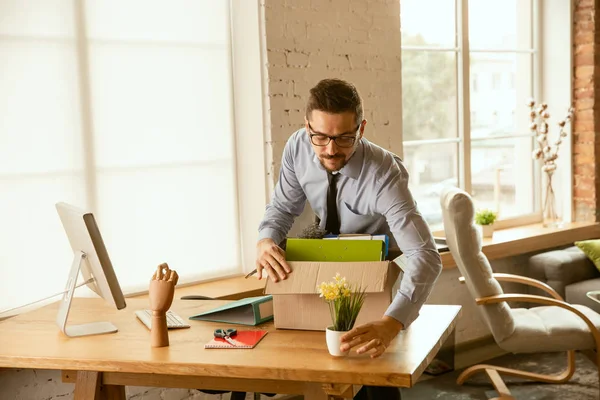 A young businessman moving in office, getting new work place