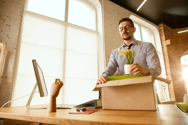 Um jovem empresário a mudar-se para o cargo, a arranjar um novo local de trabalho — Fotografia de Stock