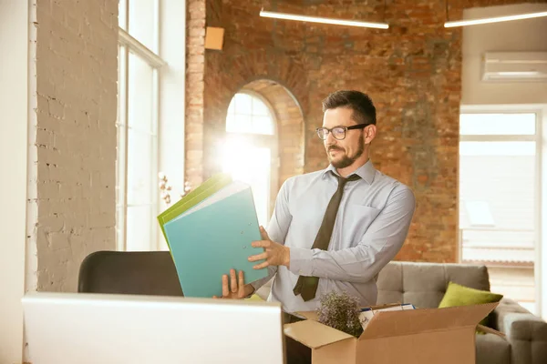 Un giovane uomo d'affari che si trasferisce in ufficio, ottenendo un nuovo posto di lavoro — Foto Stock