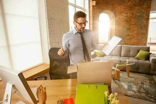 Un joven empresario que se muda a la oficina, consiguiendo un nuevo lugar de trabajo — Foto de Stock