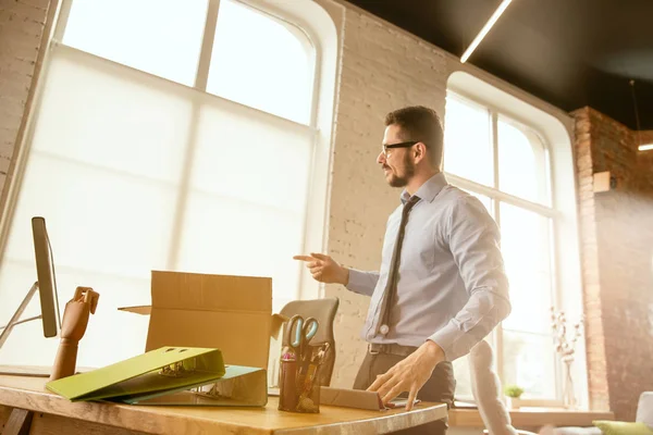 Un joven empresario que se muda a la oficina, consiguiendo un nuevo lugar de trabajo — Foto de Stock