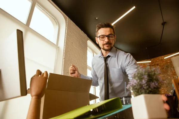 Un joven empresario que se muda a la oficina, consiguiendo un nuevo lugar de trabajo — Foto de Stock