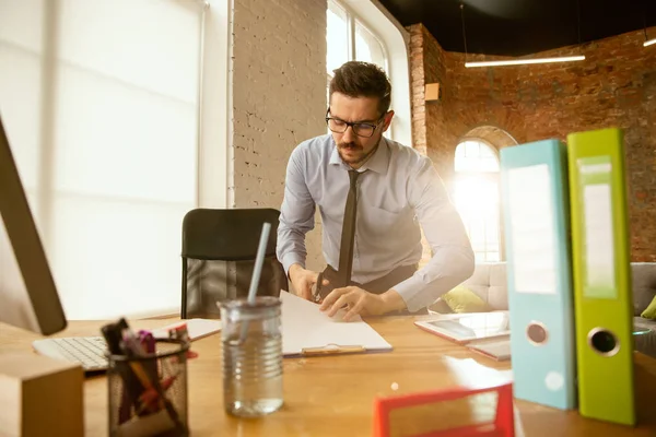 Un joven empresario que se muda a la oficina, consiguiendo un nuevo lugar de trabajo — Foto de Stock