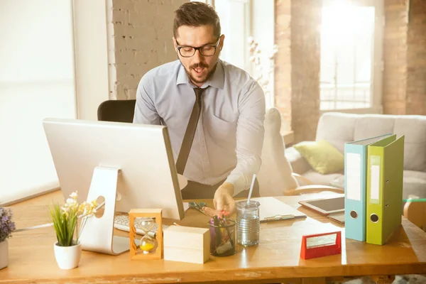 Un joven empresario que se muda a la oficina, consiguiendo un nuevo lugar de trabajo — Foto de Stock