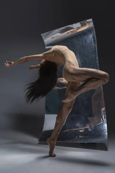 Jovem e elegante dançarina de balé moderno em fundo cinza — Fotografia de Stock