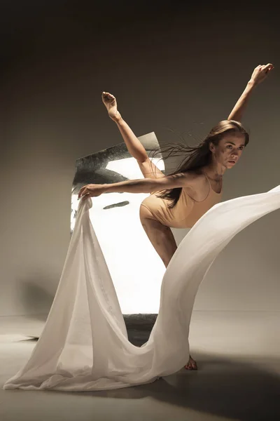 Jovem e elegante moderno bailarino de balé no fundo marrom — Fotografia de Stock