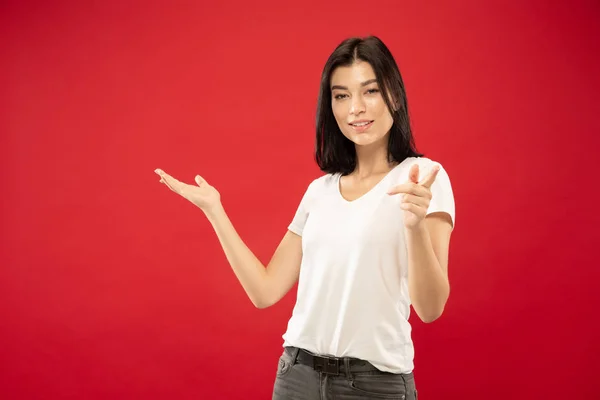 Caucasian young womans half-length portrait on red background