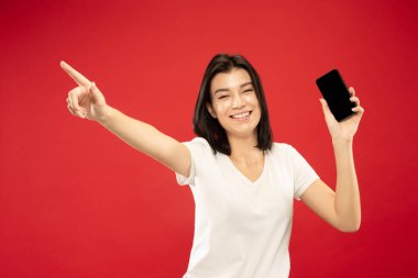 Beyaz genç kadınlar kırmızı arka plan üzerinde yarım uzunlukta portre