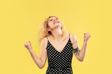 Beyaz genç kadınlar sarı arka plan üzerinde yarım uzunlukta portre