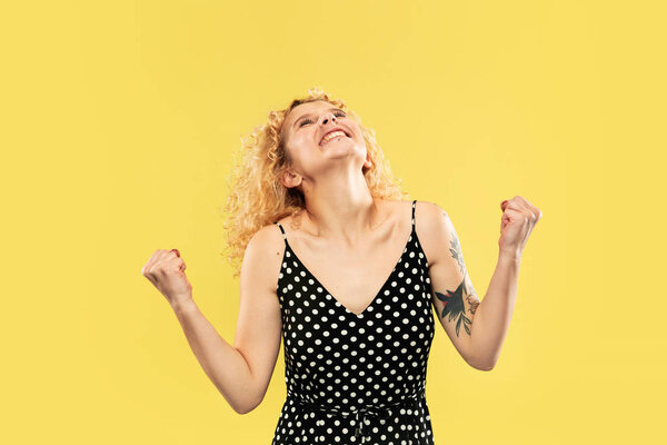 Caucasian young womans half-length portrait on yellow background