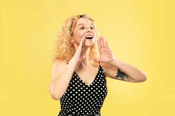 Caucasian young womans half-length portrait on yellow background