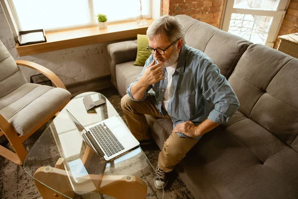 Hombre mayor que trabaja con el ordenador portátil en el hogar - concepto de estudio en el hogar — Foto de Stock