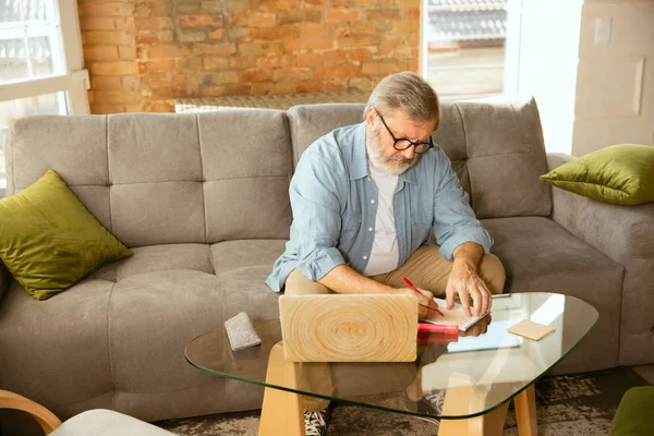 Hombre mayor que trabaja con el ordenador portátil en el hogar - concepto de estudio en el hogar — Foto de Stock