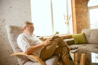 Evde tablet ile çalışan kıdemli adam - ev eğitimi kavramı
