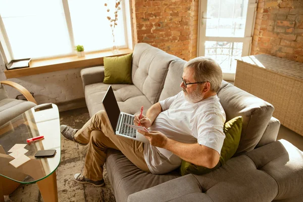 Homme âgé travaillant avec un ordinateur portable à la maison - concept d'étude à domicile — Photo