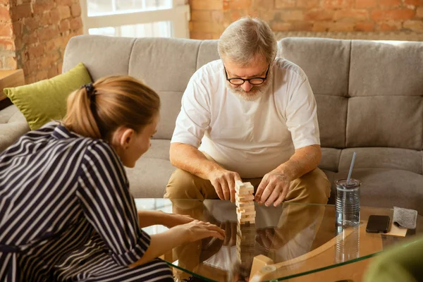 Senior man doing his wooden constructor at home - concept of home studying — Stock Photo, Image