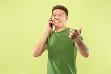 Beyaz genç adamyeşil arka plan üzerinde yarım uzunlukta portre