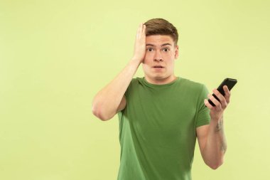 Beyaz genç adamyeşil arka plan üzerinde yarım uzunlukta portre