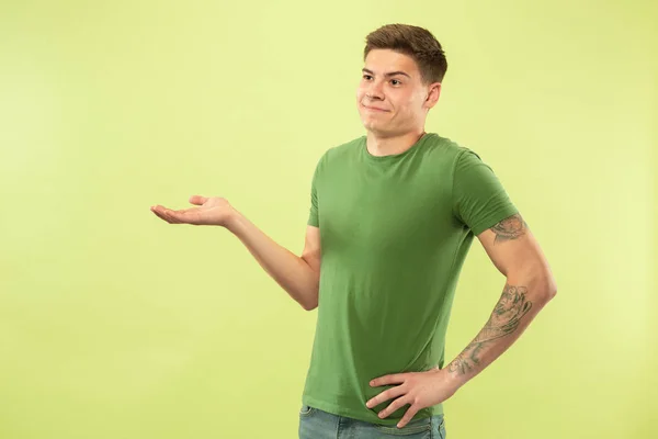 Caucasian young mans half-length portrait on green background — Stock Photo, Image