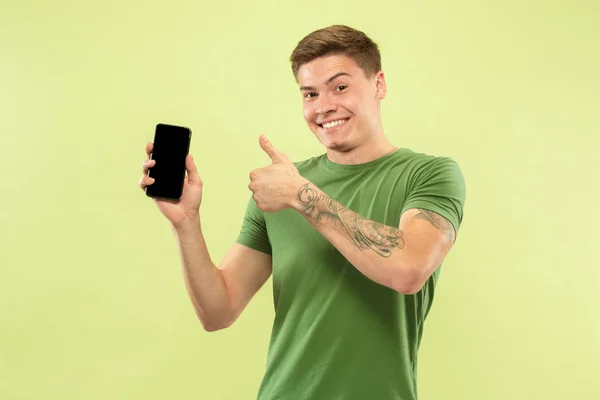 Kaukasische junge Männer halblanges Porträt auf grünem Hintergrund — Stockfoto