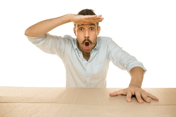 Joven abriendo el paquete postal más grande aislado en blanco — Foto de Stock