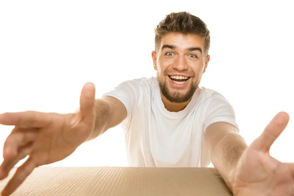 Молодий чоловік відкриває найбільший поштовий пакет ізольовано на білому — стокове фото