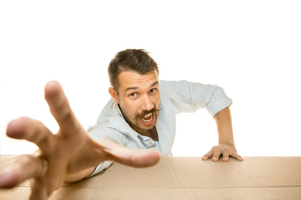 Young man opening the biggest postal package isolated on white Royalty Free Stock Photos