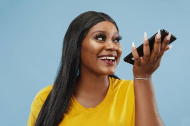 Afro-Amerikalı genç kadınların mavi arka planda yarım boy portresi