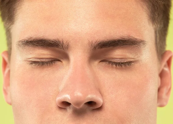 Caucasian young mans close up shot on green background