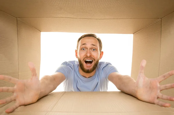 Joven abriendo el paquete postal más grande aislado en blanco —  Fotos de Stock