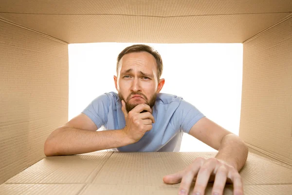 Joven abriendo el paquete postal más grande aislado en blanco — Foto de Stock