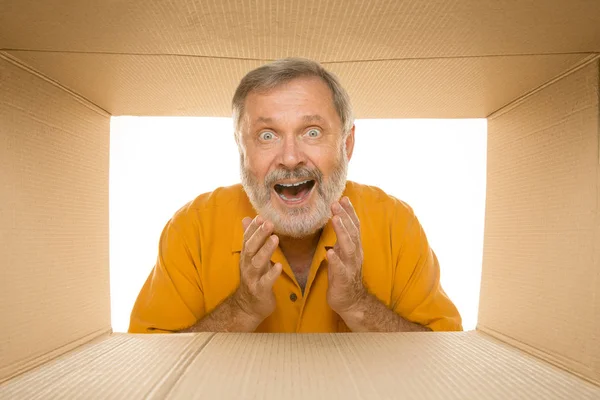 Senior öffnet das größte Postpaket isoliert auf weiß — Stockfoto