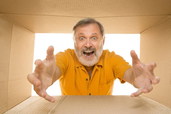 Senior öffnet das größte Postpaket isoliert auf weiß — Stockfoto