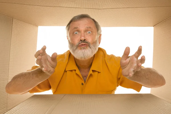 Homem sênior abrindo o maior pacote postal isolado em branco — Fotografia de Stock