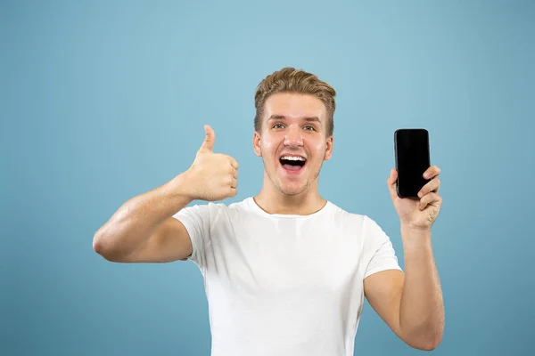 Kaukasische junge Männer halblanges Porträt auf blauem Hintergrund — Stockfoto