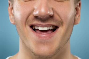 Kafkas genç adam mavi arka plan üzerinde portre kadar yakın