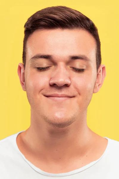 Caucasian young mans close up portrait on yellow background