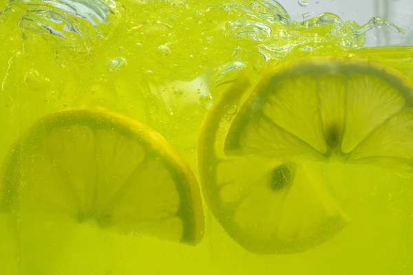 Close up view of the lemon slices in lemonade on background — Stock Photo, Image