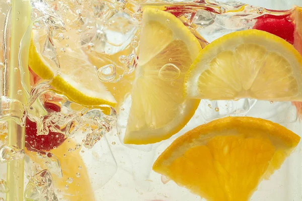 Close up blik op de citroenschijfjes in limonade op achtergrond — Stockfoto