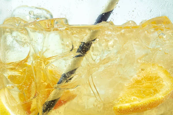 Close-up vista das fatias de limão em limonada no fundo — Fotografia de Stock