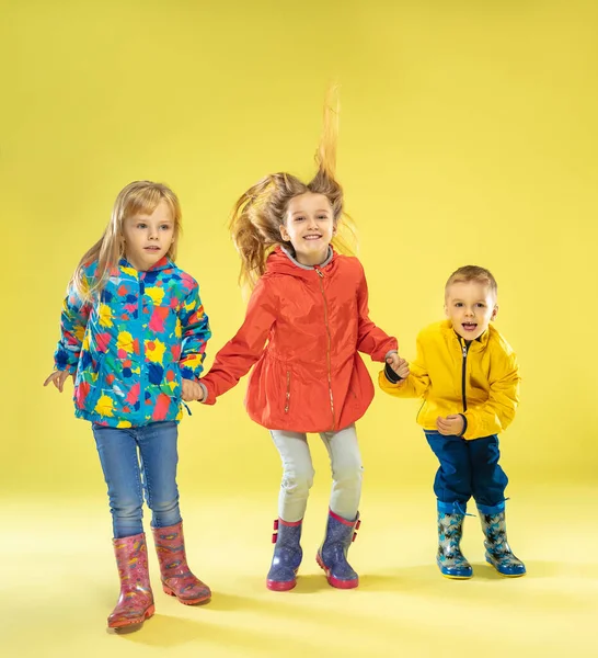 Um retrato de comprimento total de um brilhante crianças na moda em uma capa de chuva — Fotografia de Stock