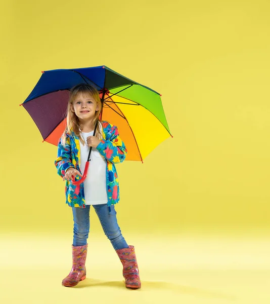 Un ritratto a figura intera di una ragazza alla moda luminosa in un impermeabile — Foto Stock